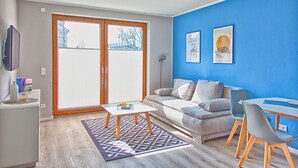 Una sala de estar moderna con un sofá gris, una mesa de centro y un comedor con mesa y sillas.