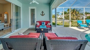 A covered patio with wicker furniture, a ceiling fan, and a view of the outdoors. - Long Water View, Pool, Kayaks, Bikes, Views,116 Reviews! Villa 21 (Cape Coral)