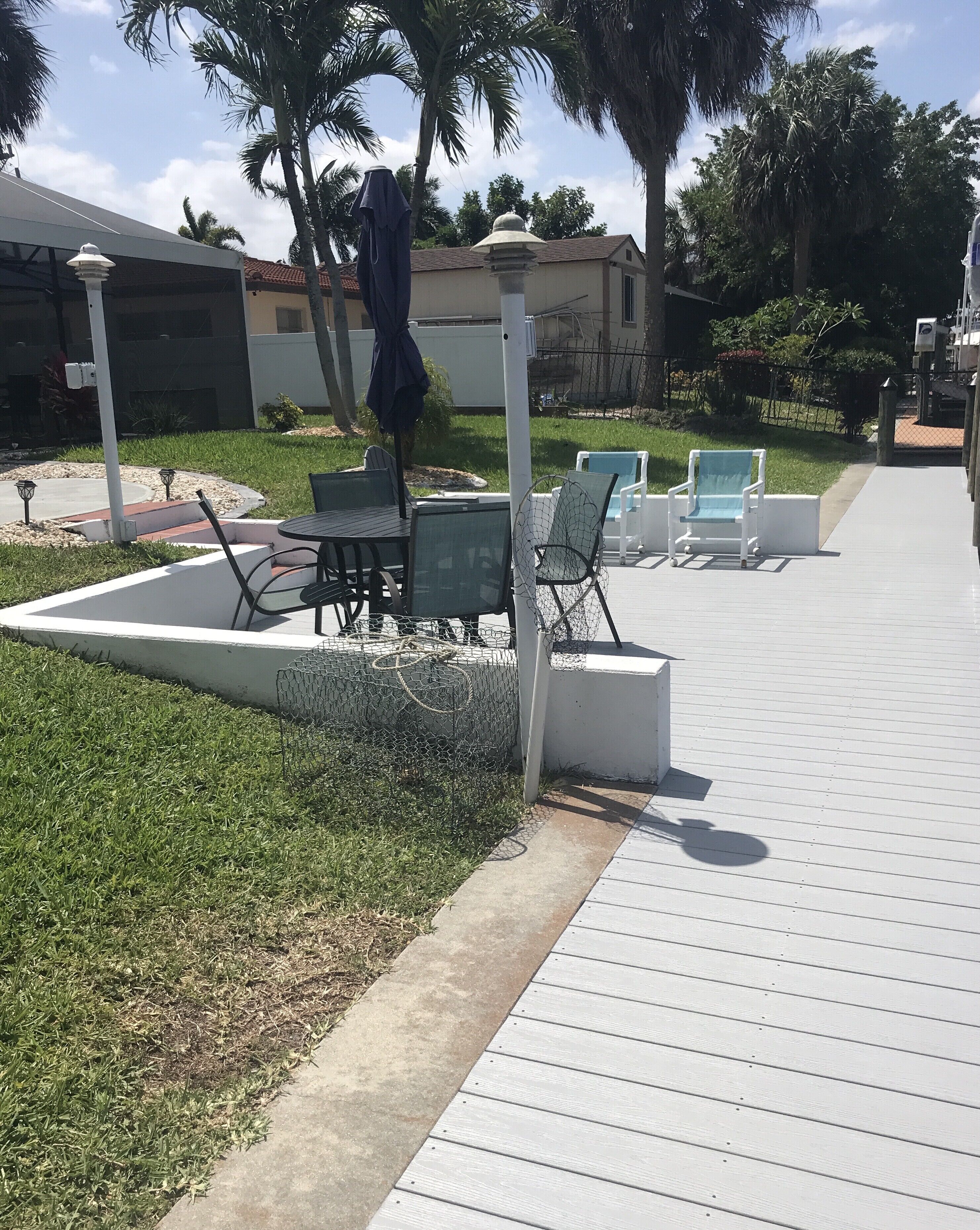 Un espace extérieur aménagé avec une table de billard, des chaises et un coin salon abrité.