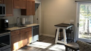 Una cocina compacta con armarios de madera, microondas, lavavajillas y ventilador de techo.