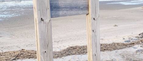 A wooden signboard with a list of shellfish types available for harvesting.