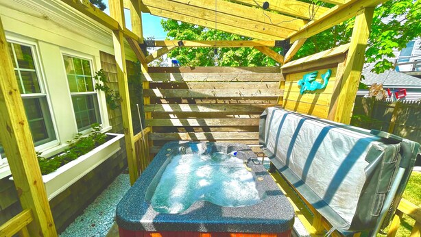 A wooden deck with a hot tub, surrounded by a wooden pergola and a wooden fence. - West Dennis Central - 5 bed, 3 bath, 2 kitchen huge yard!
Two hot tubs! (Dennis)