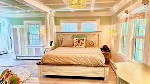 A bedroom with a wooden bed, a nightstand, a dresser, and a large window with blinds. - West Dennis Central - 5 bed, 3 bath, 2 kitchen huge yard!
Two hot tubs! (Dennis)