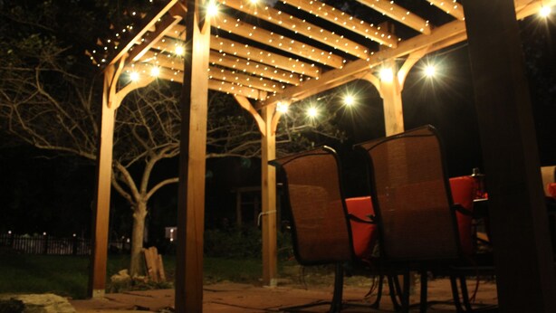 A wooden pergola with string lights, two wooden chairs, and a stone pathway. - Historic, quiet, elegant, mix of modern & original (Dubuque)
