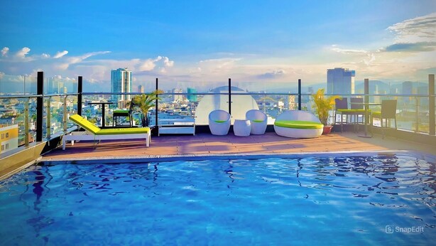 Piscina en la azotea con mobiliario moderno y vistas a la ciudad.