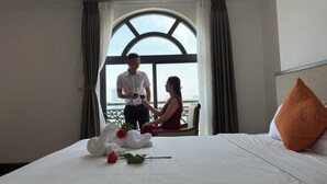 Una habitación de hotel con cama, ventana con cortinas y vista a la ciudad.
