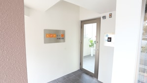 Entrada de un hotel con un cartel que indica el tipo de habitación y su nombre.