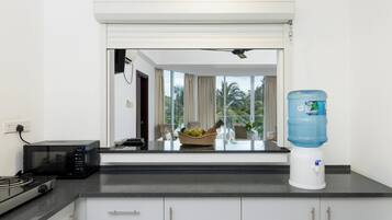 A modern kitchen with a microwave, stove, and water dispenser.