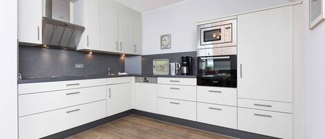 Mikrobølgeovn, ovn, oppvaskmaskin og høy barnestol