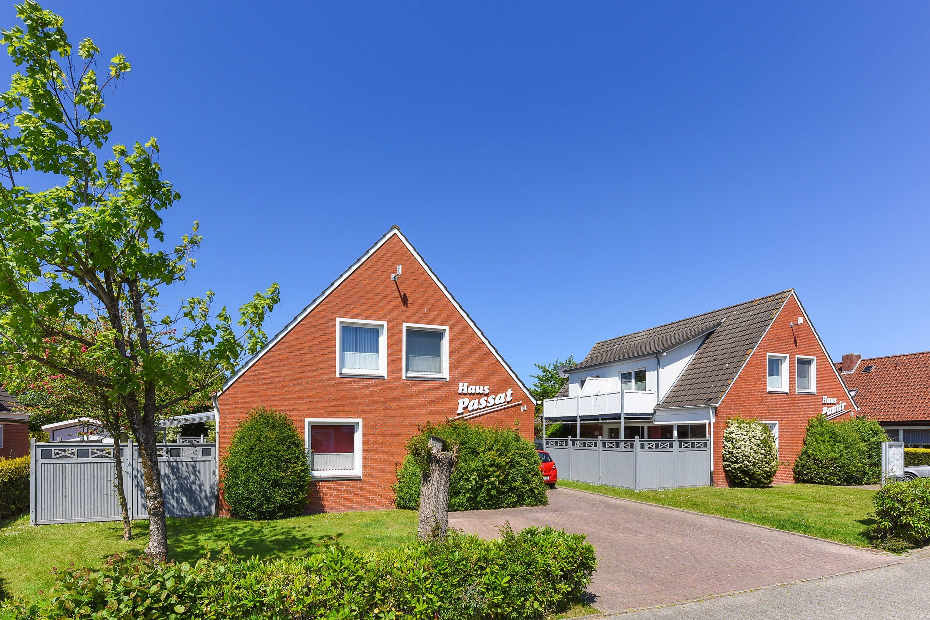 Een rode bakstenen huis met een bord waarop 
