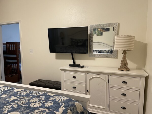 A bedroom with a bed, dresser, TV, mirror, and lamp. - 1b/1b for 6 max4adults! Heated pools! Steps from the BEACH! Netflix! Playground! (Corpus Christi)