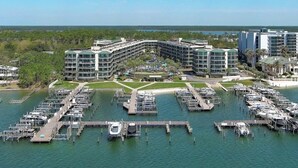 Een jachthaven met aangemeerde boten, omringd door een hotelcomplex met meerdere gebouwen en een helder uitzicht op het water.