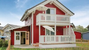 A two-story house with a red exterior, white balcony railings, and a front door. - Beautiful home in Süssau/Ostsee (Süssau/Ostsee)