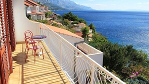 Ein Balkon mit Blick auf das Meer und die Berge.