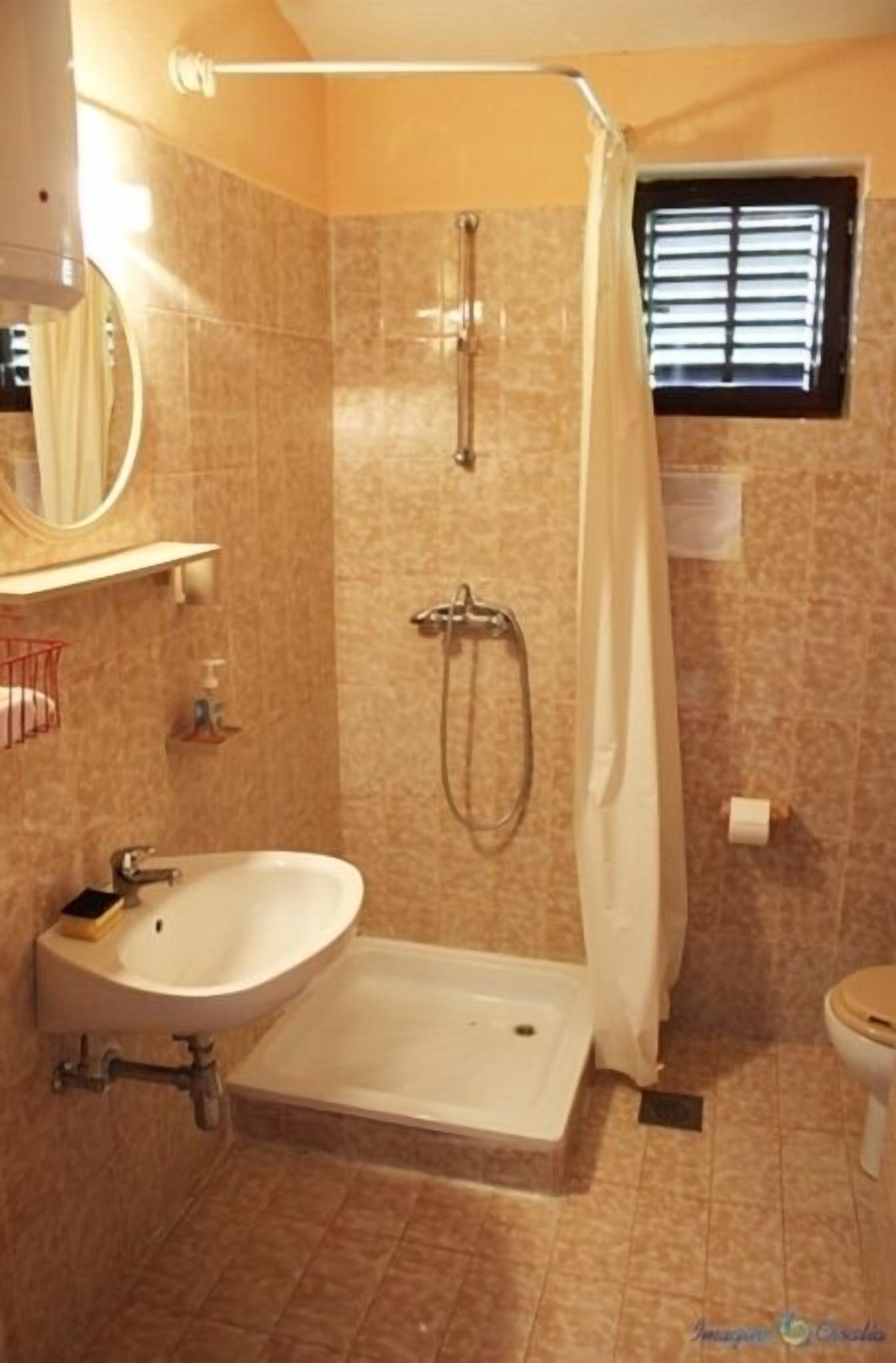 Une salle de bain avec une douche, un lavabo et des toilettes.