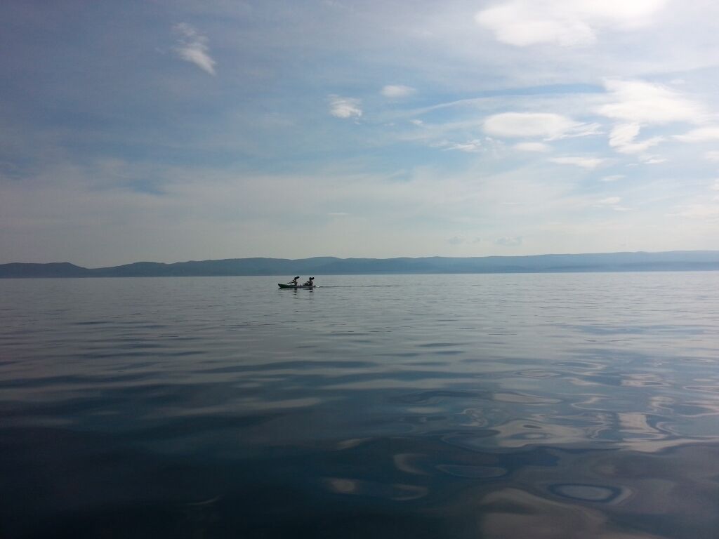 A calm lake with a small boat in the distance.