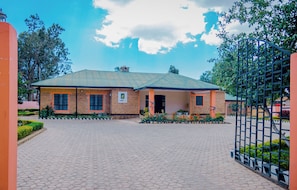 A two-story building with a brick facade, a flat roof, and a paved entrance area. - Zakinn Hotel Gangilonga Iringa (Iringa)