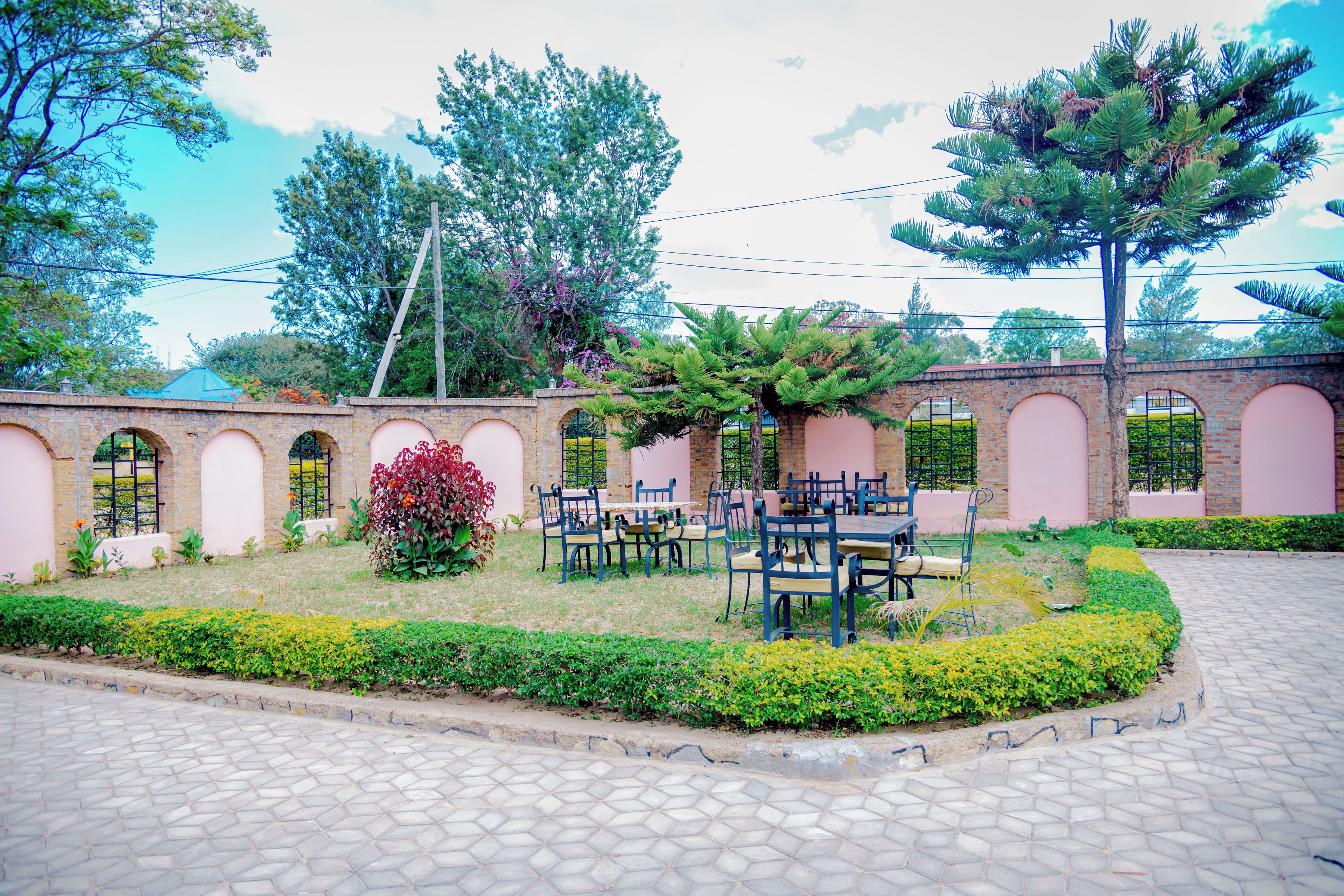 A courtyard with a brick wall, a garden with various plants, and outdoor seating.
