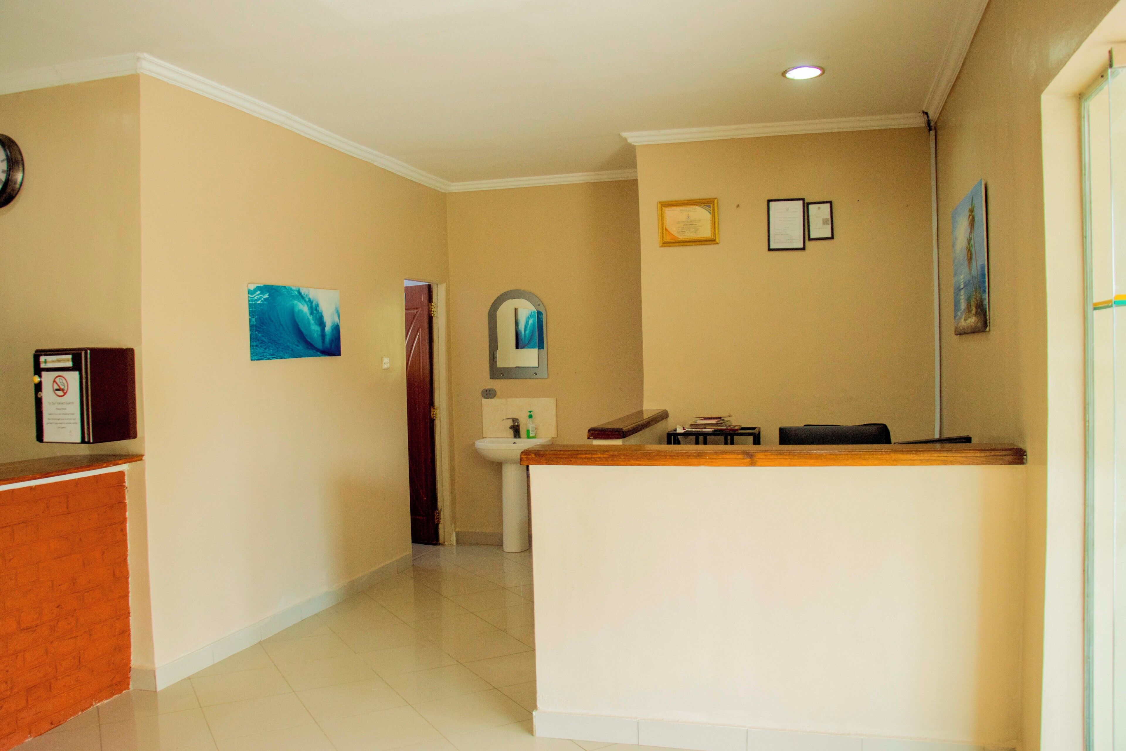 A reception area with a reception desk, a clock, and a wall-mounted mirror.
