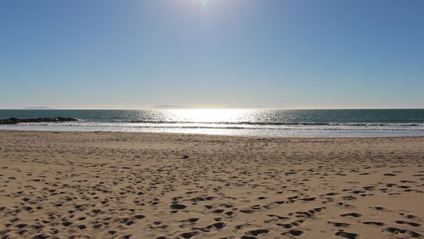 A beach with footprints in the sand and a clear sky. - Contemporary Home In The Ventura Keys (Ventura)