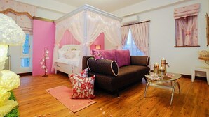 A bedroom with a four-poster bed, a sofa, a small table, and a decorative floor lamp. - Happiness Garden (Ji'an)
