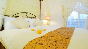 A hotel room with a bed, pillows, a lamp, and a stuffed toy. - Happiness Garden (Ji'an)