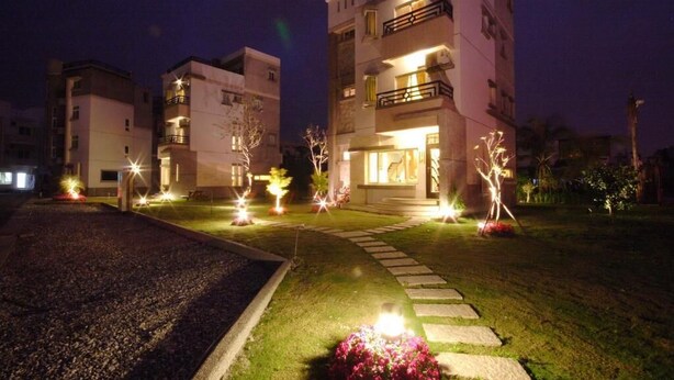 A multi-story residential building with illuminated entryways and a well-maintained lawn. - Happiness Garden (Ji'an)