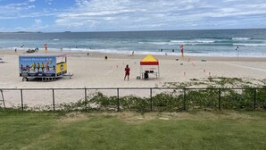 A beach with a lifeguard station, a food truck, and a tent. - Kingscliff Waterfront - large pool, direct creek access & 5 mins walk to beach (Kingscliff)
