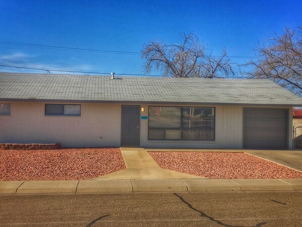 A single-story building with a flat roof, a garage door, and a small window.