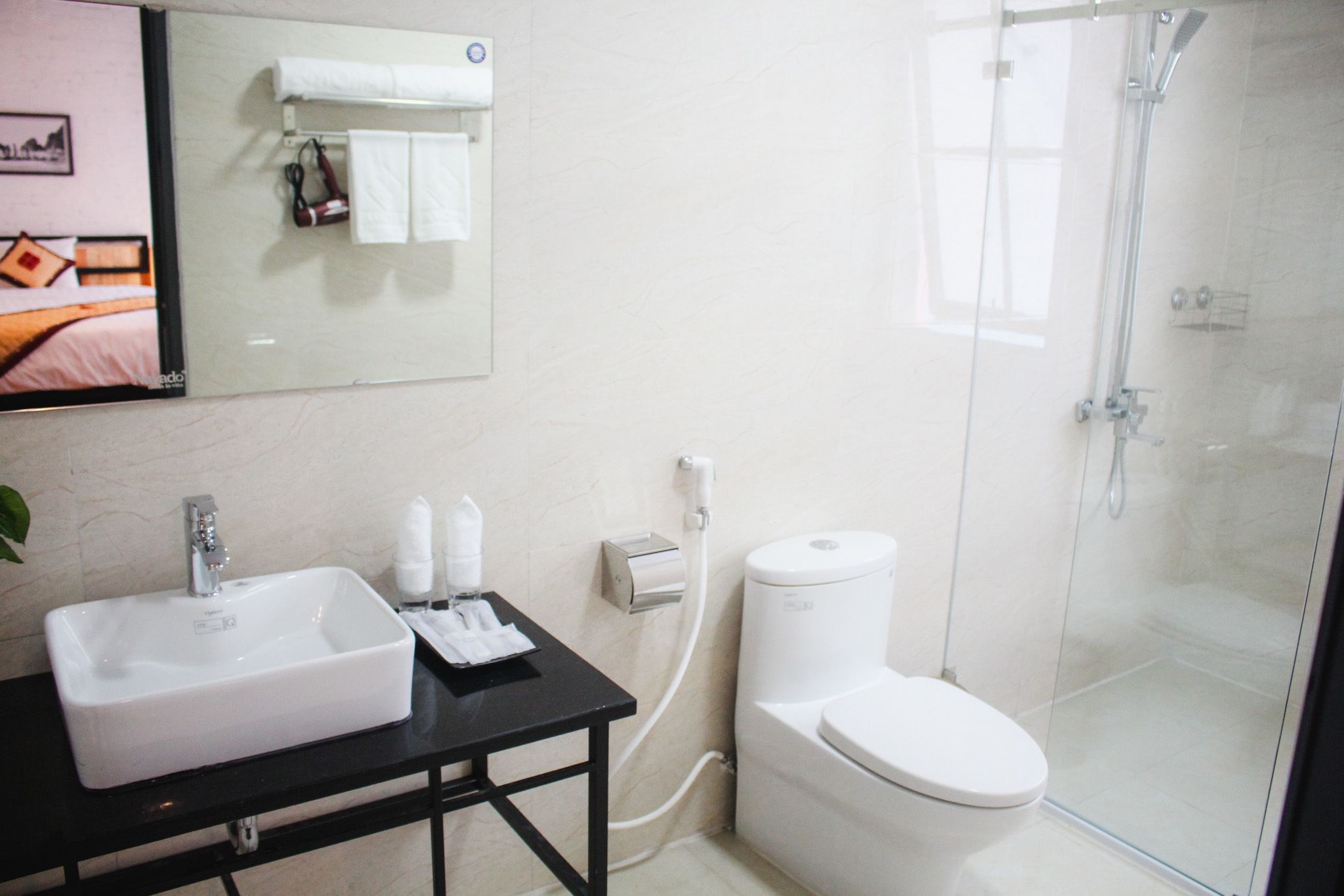 Ein modernes Badezimmer mit Waschbecken, Toilette und einer Duschkabine aus Glas.