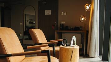 A modern living room with a leather armchair, a wooden coffee table, and a floor lamp.