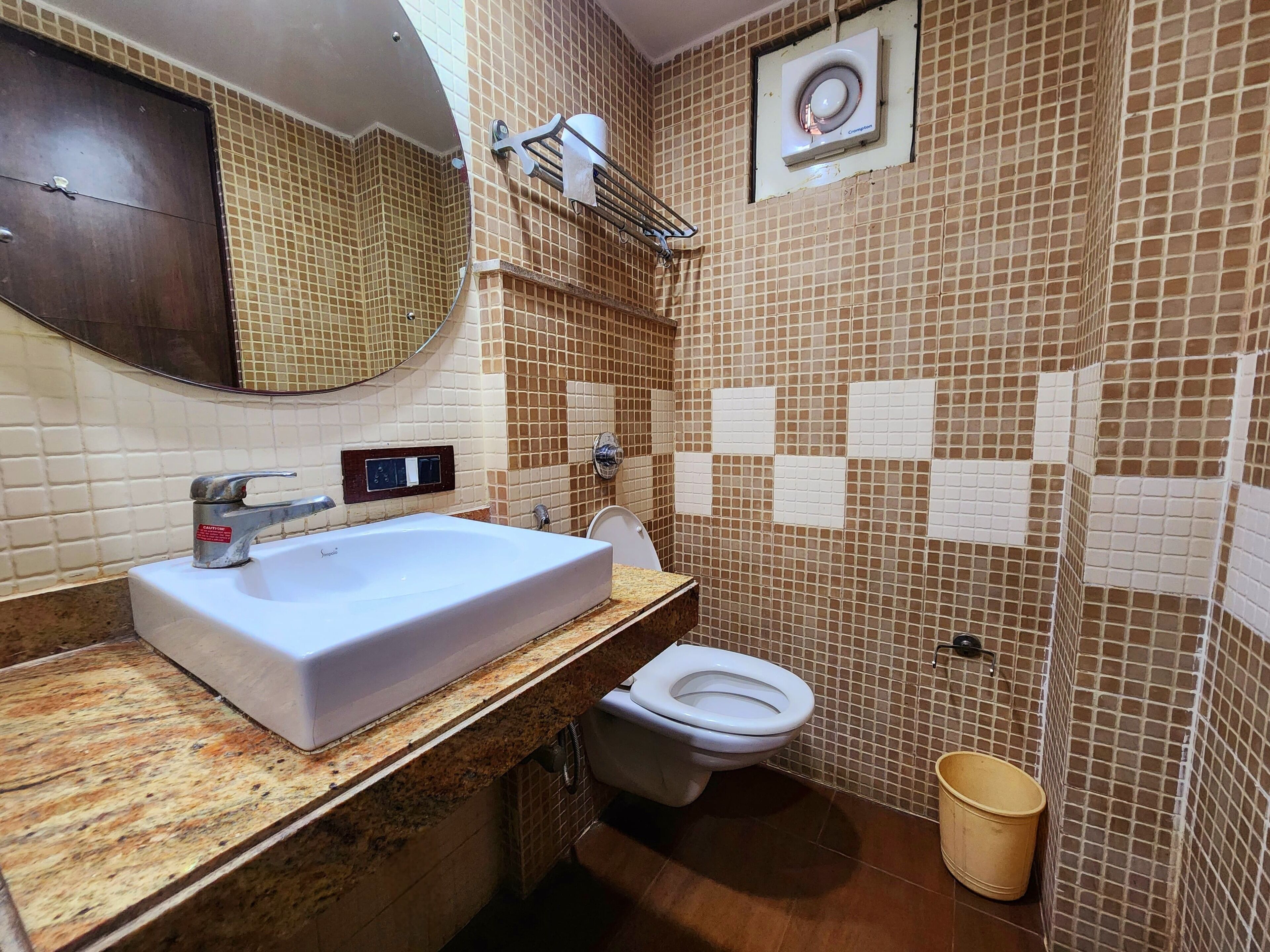A bathroom with a large sink, toilet, and a shower area.