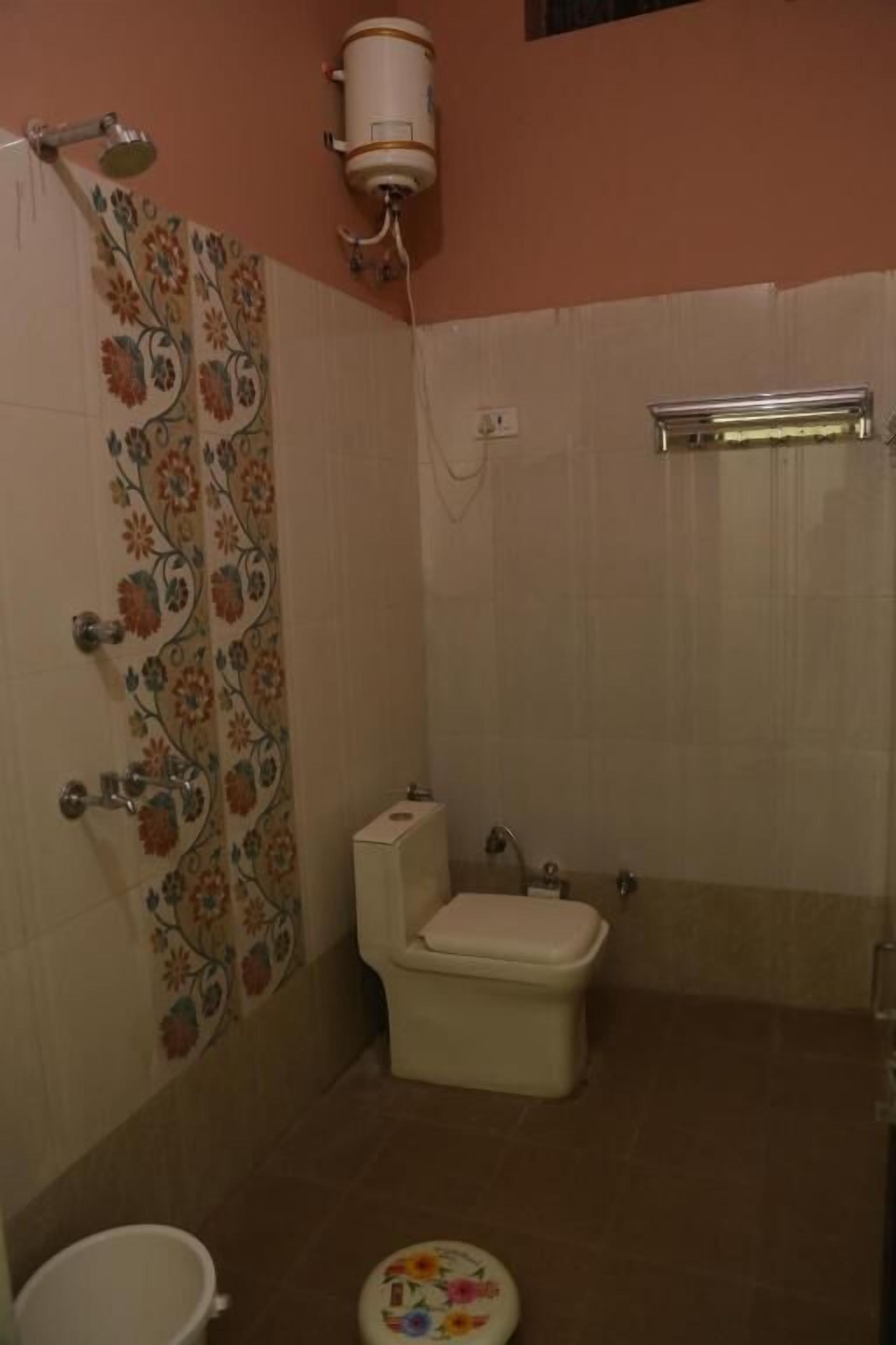 A bathroom with a toilet, shower, and a small sink.