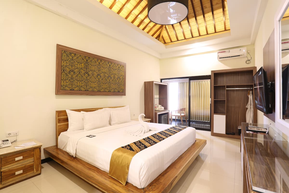 Une chambre d’hôtel avec un lit en bois, une grande œuvre d’art au mur, une armoire, un bureau avec une chaise et un téléviseur.