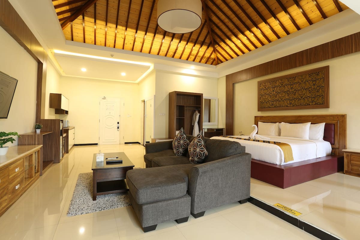 Une chambre d’hôtel moderne équipée d’un grand lit, d’un canapé, d’un bureau et d’une armoire.