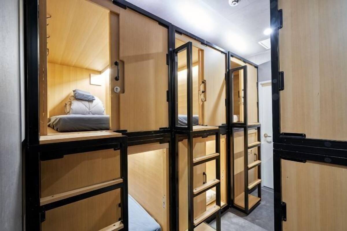 Una habitación con una cama litera, un escritorio pequeño y un armario.