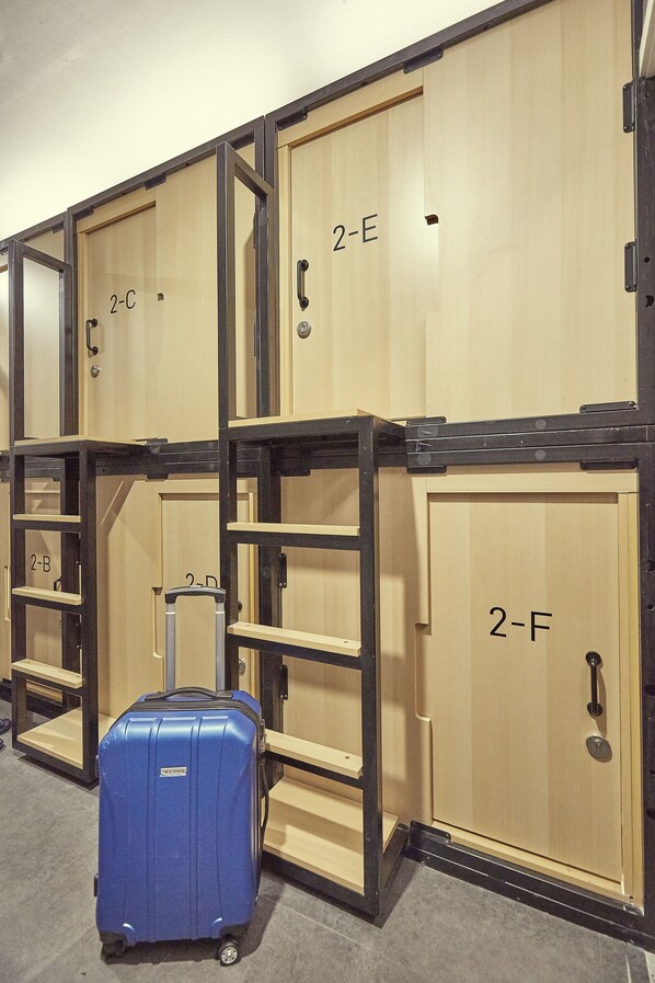 A row of wooden storage lockers with metal frames, each labeled with a number. - THE CAPSULE Myeongdong (Seoul)