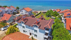 A coastal residential area with houses featuring red-tiled roofs and a view of the sea. - Ergul Apart Hotel (Kandira)