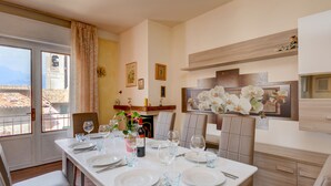 Un coin repas avec une table dressée pour quatre personnes, des chaises et une vue sur l’extérieur.