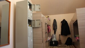 A compact bedroom with a wardrobe, a guitar, and a suitcase. - Almaty Hostel Dom (Almaty)