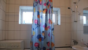 A bathroom with a shower, a sink, and a washing machine. - Almaty Hostel Dom (Almaty)