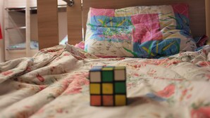 A bed with a colorful quilt and a Rubik's cube on it. - Almaty Hostel Dom (Almaty)