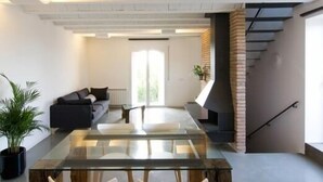 Een moderne woonkamer met een glazen salontafel, een bank en een open haard.