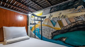 Una habitación con una cama, cabecera de madera y un mural que muestra un puente y montañas.