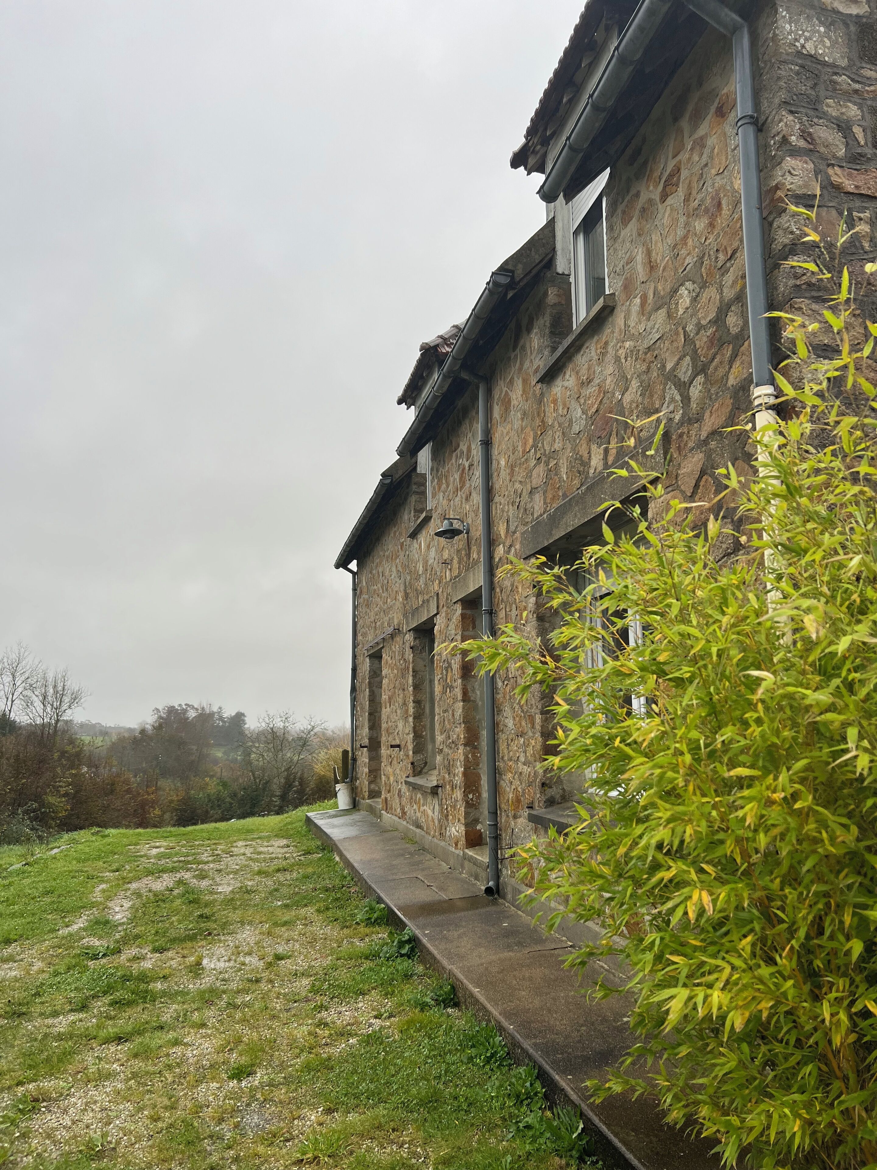 A stone building with a concrete pathway leading to the entrance.
