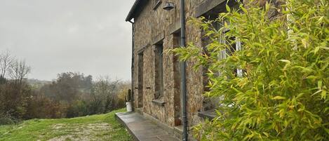 A stone building with a concrete pathway leading to the entrance.