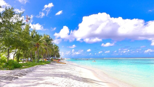 A beach with white sand, palm trees, and clear turquoise water. - Casa Retreat (Hulhumalé)