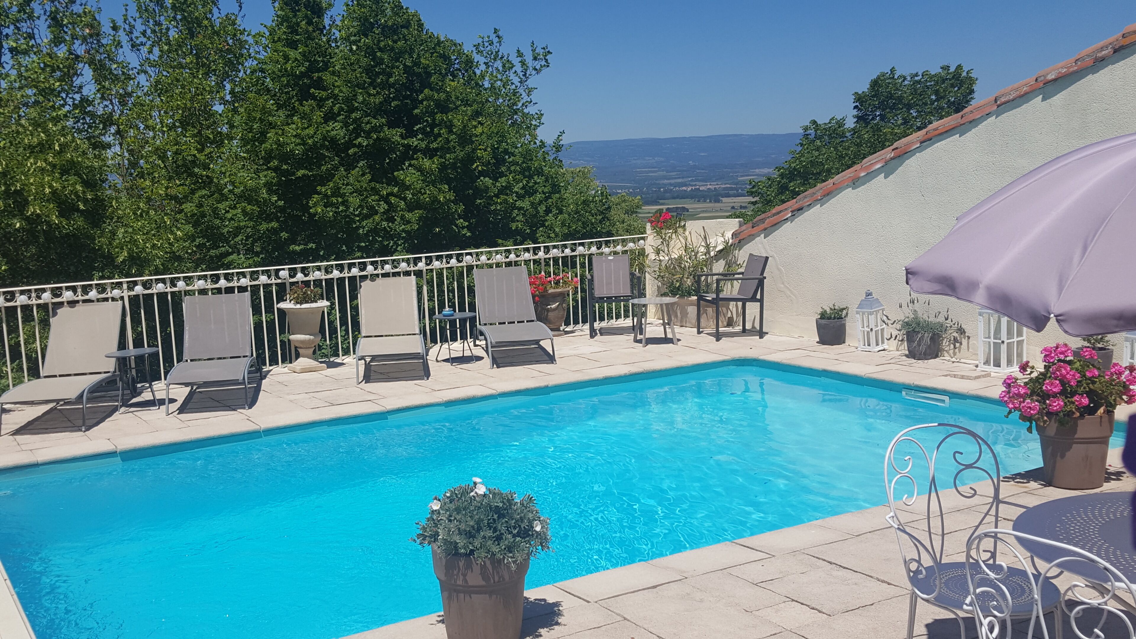 Una piscina con sillas de descanso y vistas del paisaje.