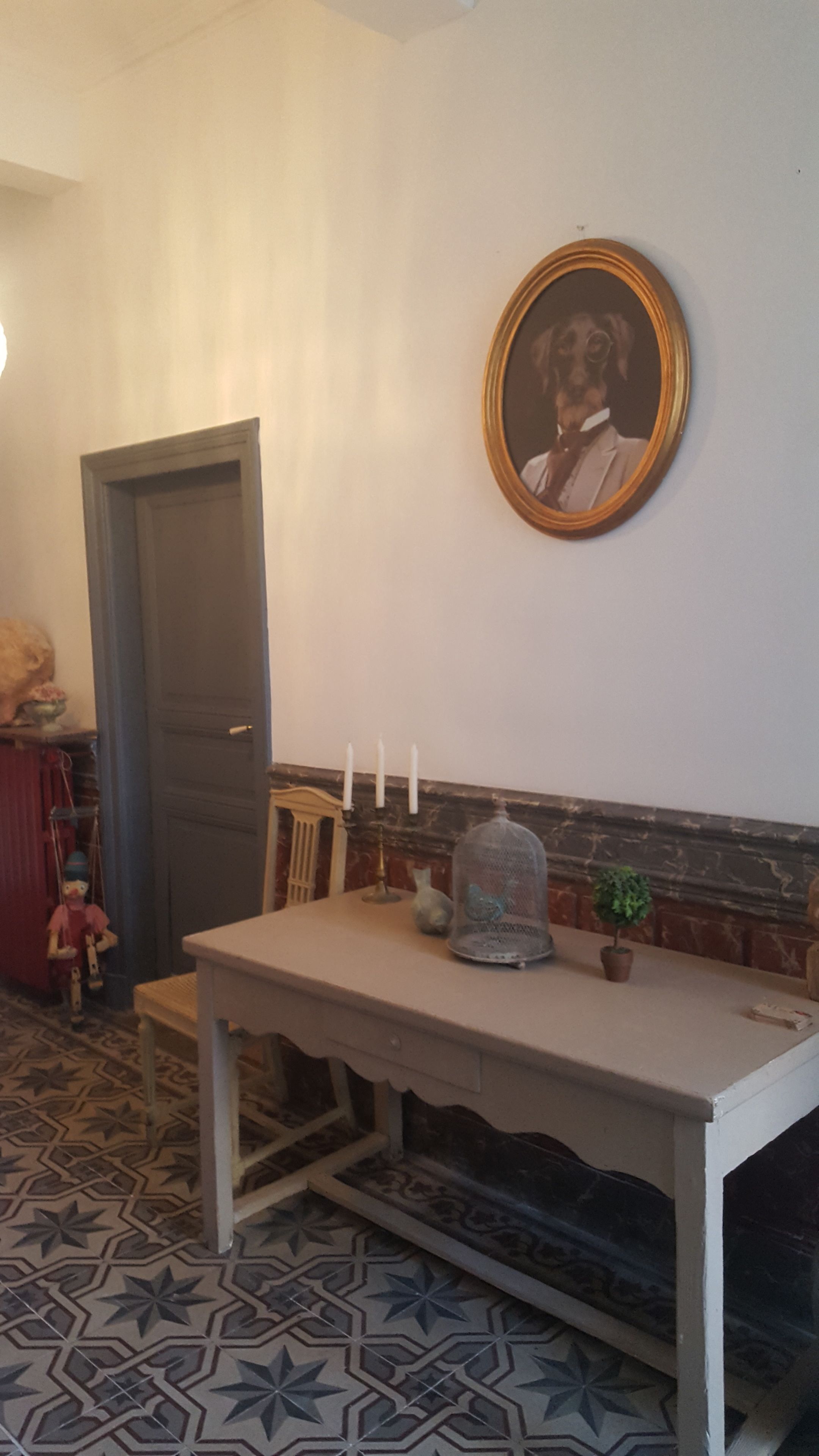 Una habitación con una mesa blanca, un espejo en la pared y una puerta.
