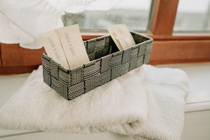 A checkered basket with items labeled "HAIR & BODY" on a white towel by a window. - Fränkischer  Gasthof  Hotel Zum Koppen (Gemuenden)